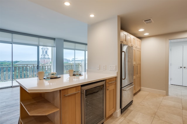 kitchen with kitchen peninsula, expansive windows, beverage cooler, stainless steel refrigerator, and light tile patterned flooring