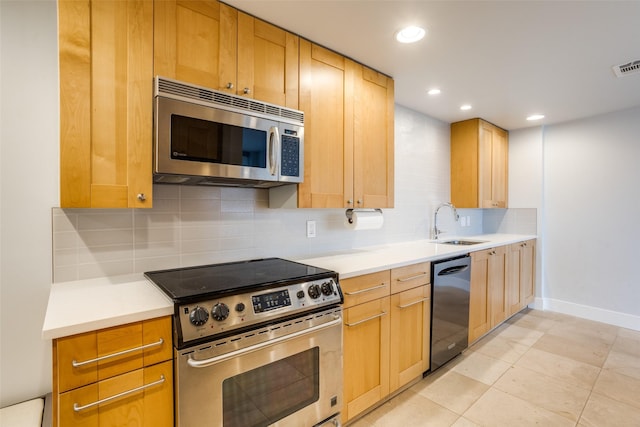 kitchen with stainless steel appliances, tasteful backsplash, sink, and light tile patterned floors