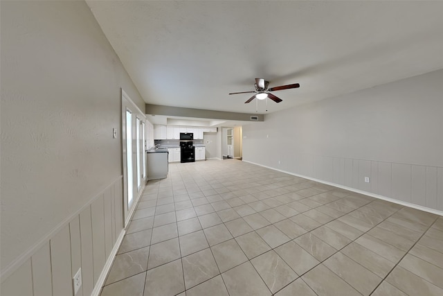 unfurnished living room with ceiling fan and light tile patterned floors