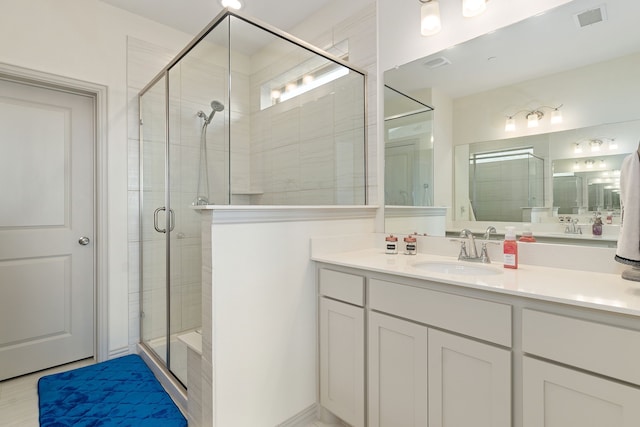 bathroom featuring vanity and a shower with shower door