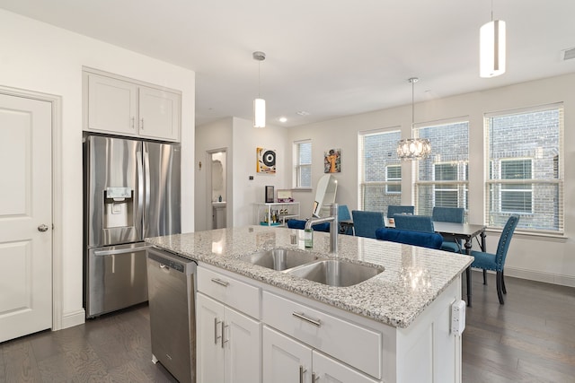 kitchen featuring white cabinets, appliances with stainless steel finishes, hanging light fixtures, and dark wood-type flooring