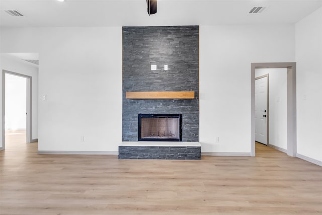 unfurnished living room with a fireplace and light wood-type flooring