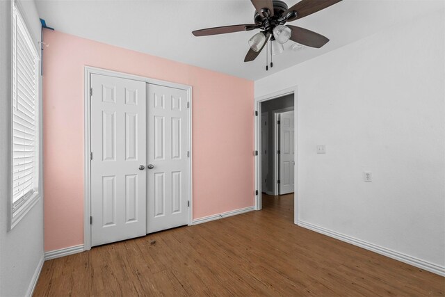 unfurnished bedroom with wood-type flooring, a closet, and ceiling fan