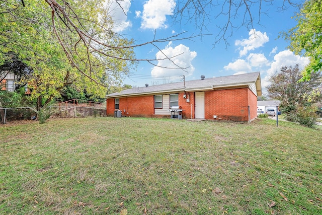 rear view of property featuring a lawn