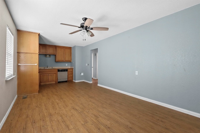 kitchen with ceiling fan, light hardwood / wood-style flooring, white dishwasher, and built in desk