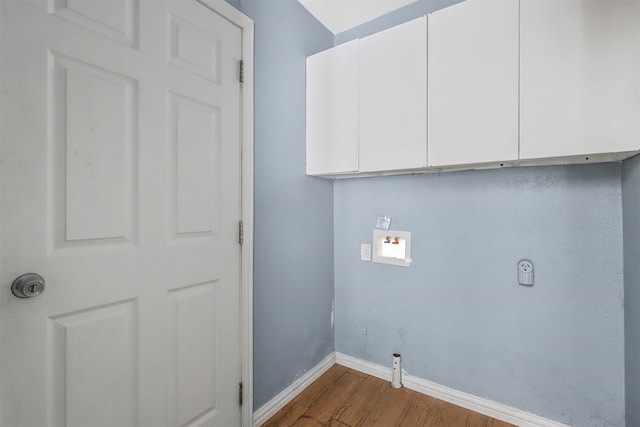 laundry area with hardwood / wood-style floors and cabinets