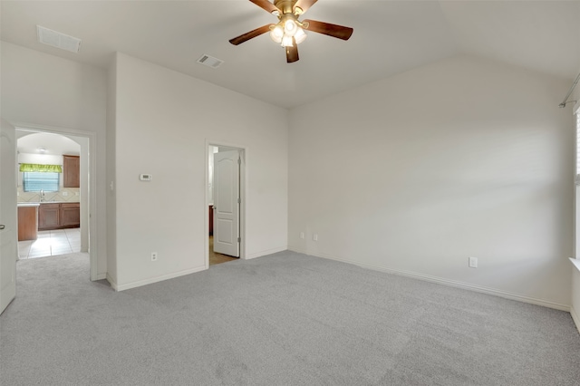 empty room with ceiling fan, light colored carpet, and lofted ceiling