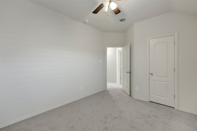 unfurnished bedroom with light colored carpet, vaulted ceiling, and ceiling fan