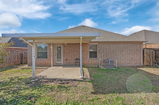 back of house featuring a lawn, central AC unit, and a patio area