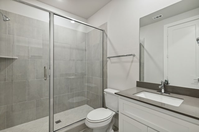 bathroom with vanity, toilet, and an enclosed shower