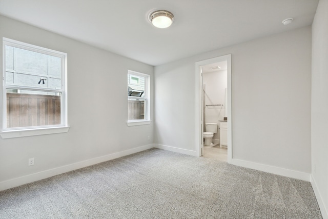 unfurnished bedroom featuring carpet and ensuite bathroom