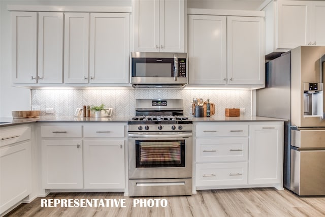 kitchen with decorative backsplash, white cabinetry, light hardwood / wood-style floors, and appliances with stainless steel finishes