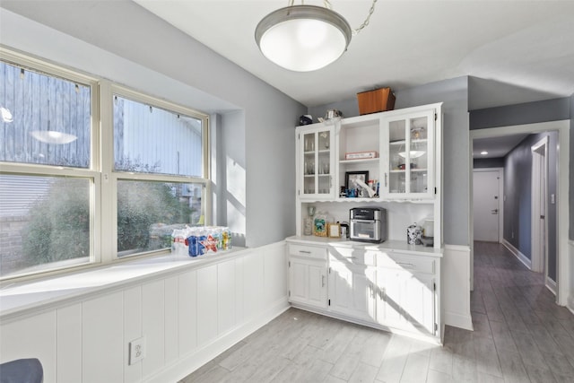 kitchen with light hardwood / wood-style floors and white cabinets