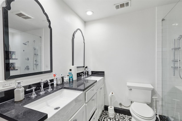 bathroom featuring tile patterned floors, vanity, toilet, and tiled shower