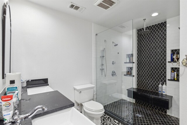 bathroom with walk in shower, vanity, and toilet