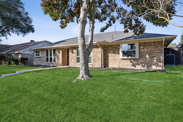 ranch-style home with cooling unit and a front yard