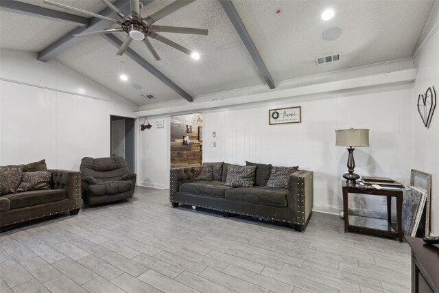 living room featuring vaulted ceiling with beams, ceiling fan, and a textured ceiling