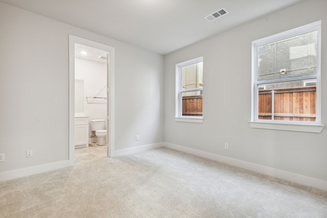 spare room featuring light carpet