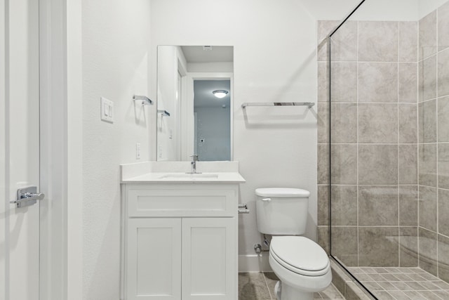 bathroom featuring tiled shower, vanity, and toilet