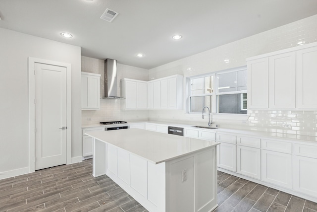 2543 Carolwood Ln, Dallas, TX 75212 - kitchen with wood tiled floor, a center island, visible vents, a sink, and wall chimney range hood