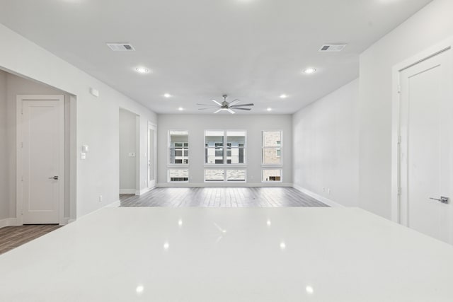 unfurnished living room with hardwood / wood-style flooring and ceiling fan