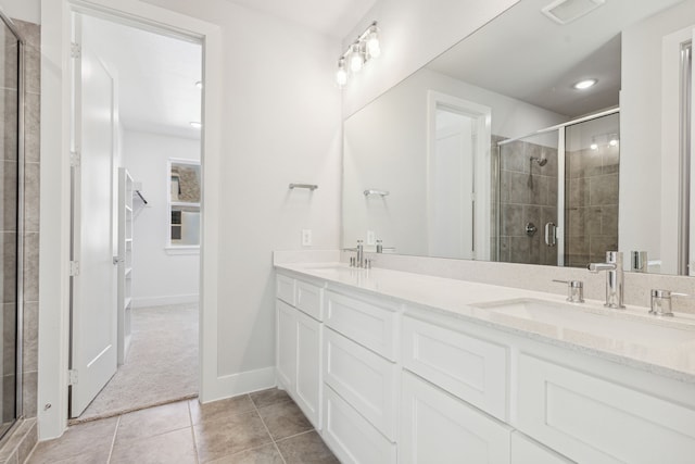 bathroom with tile patterned floors, a shower with door, and vanity