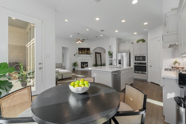 dining space with ceiling fan, dark hardwood / wood-style flooring, and sink