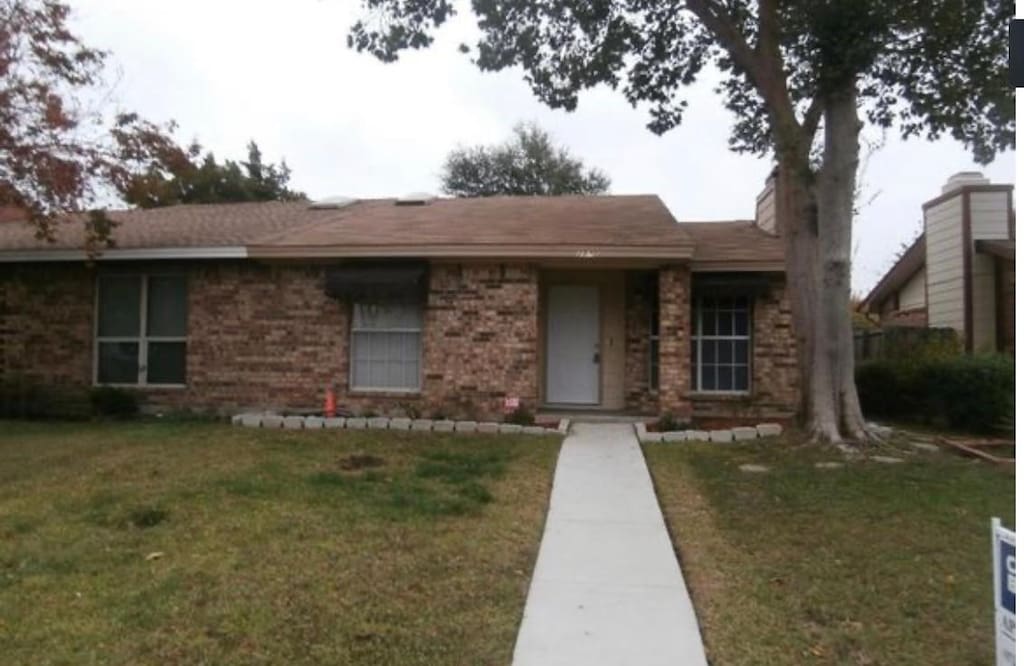 single story home featuring a front lawn