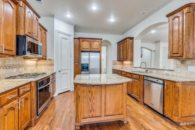 spare room featuring ceiling fan, light wood-type flooring, ornamental molding, and a tray ceiling