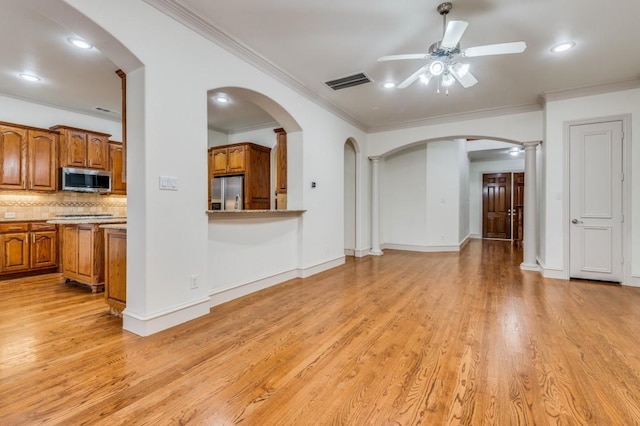 unfurnished living room with light hardwood / wood-style flooring, ornamental molding, ceiling fan, and ornate columns