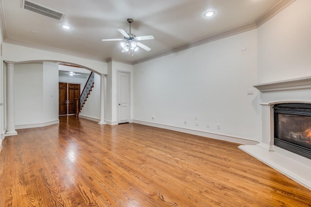 unfurnished living room with light hardwood / wood-style flooring, ornamental molding, decorative columns, and ceiling fan