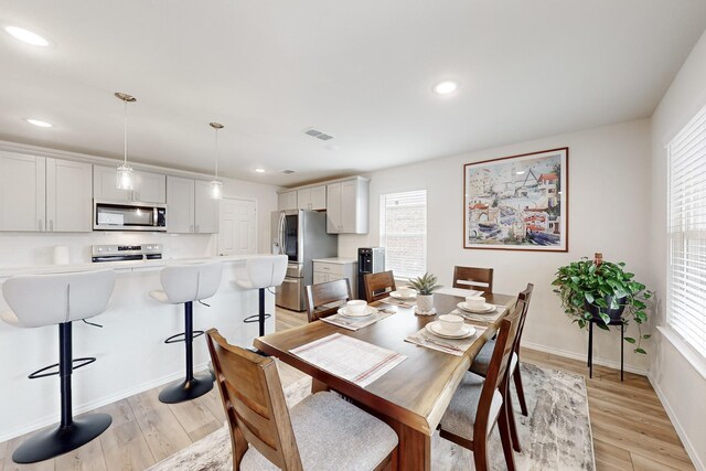 dining area featuring light wood finished floors, baseboards, visible vents, and recessed lighting