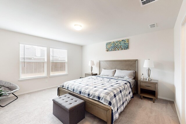 bedroom with baseboards, visible vents, and light colored carpet