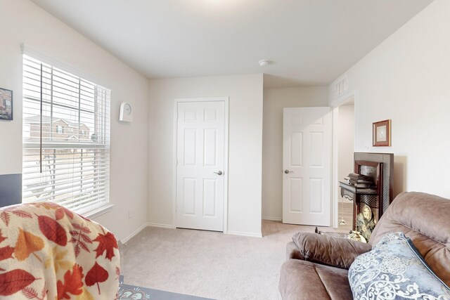 carpeted living room with visible vents and baseboards