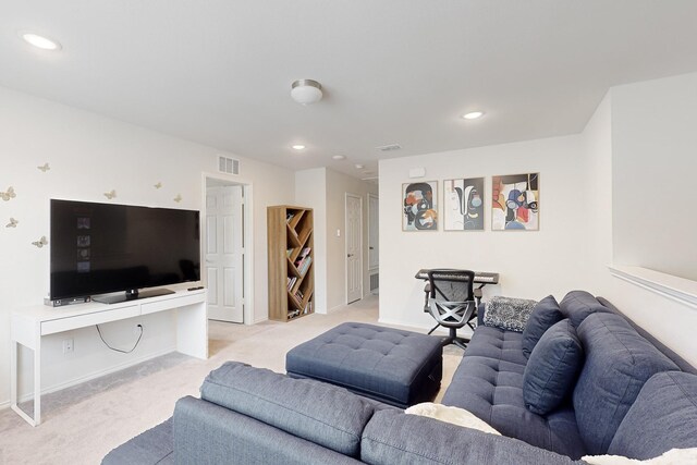 living area with recessed lighting, visible vents, and light colored carpet