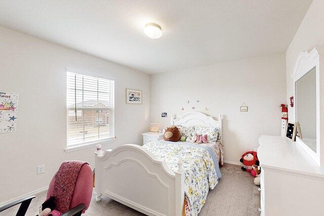 bedroom featuring light colored carpet and baseboards