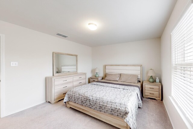 bedroom with light colored carpet, visible vents, and baseboards