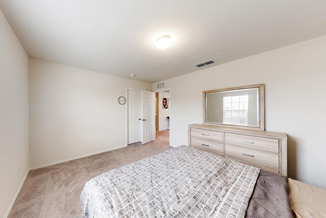 bedroom featuring light colored carpet, visible vents, and baseboards