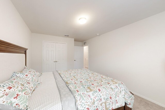 bedroom featuring carpet floors, a closet, visible vents, and baseboards