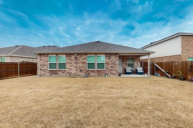 back of house featuring a shingled roof, a fenced backyard, a patio, and brick siding