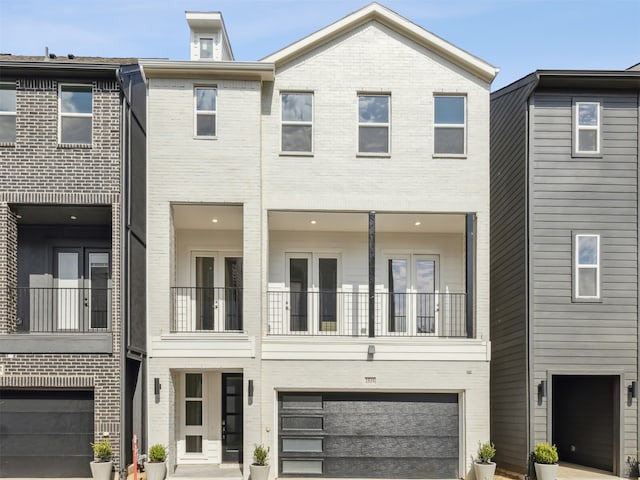 view of property featuring an attached garage, driveway, and brick siding