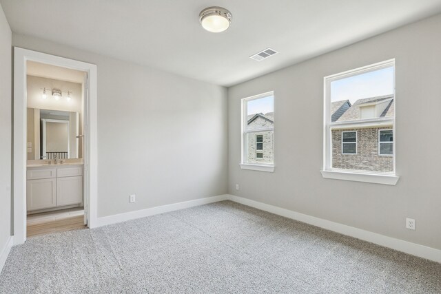 empty room with sink and light colored carpet