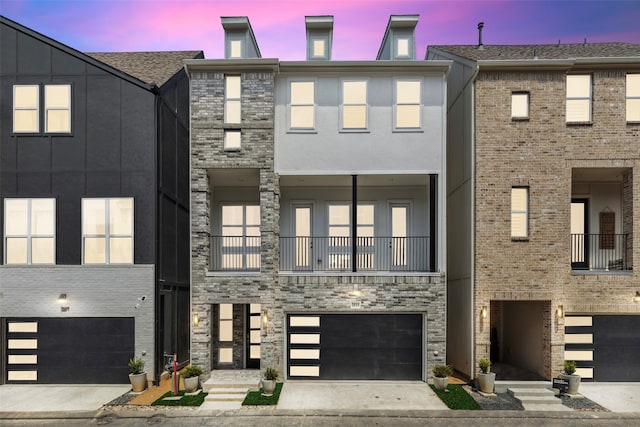 view of front facade with a garage and a balcony