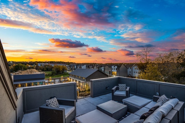 patio terrace at dusk with outdoor lounge area and a balcony
