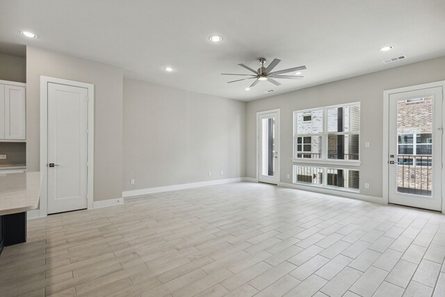 unfurnished living room featuring light hardwood / wood-style flooring and ceiling fan