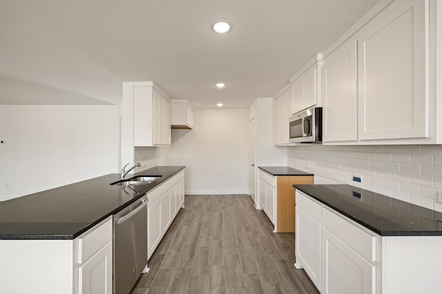 kitchen featuring stainless steel appliances, light hardwood / wood-style floors, sink, and white cabinets