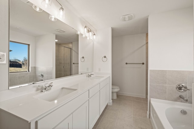 bathroom with toilet, vanity, a bath, and tile patterned flooring