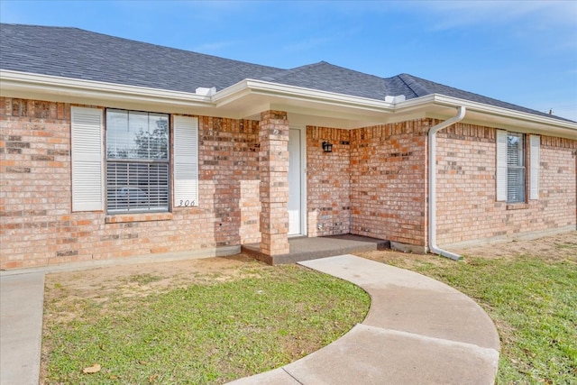 doorway to property with a lawn