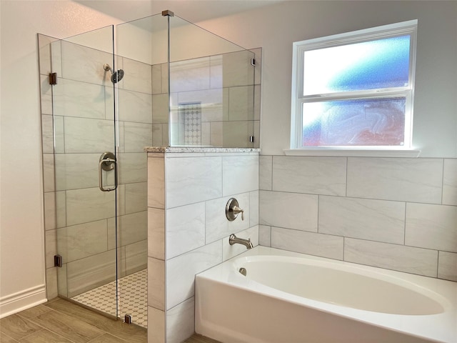 bathroom with hardwood / wood-style flooring and separate shower and tub