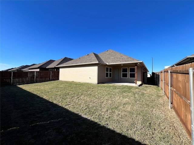 rear view of property with a lawn and a patio area